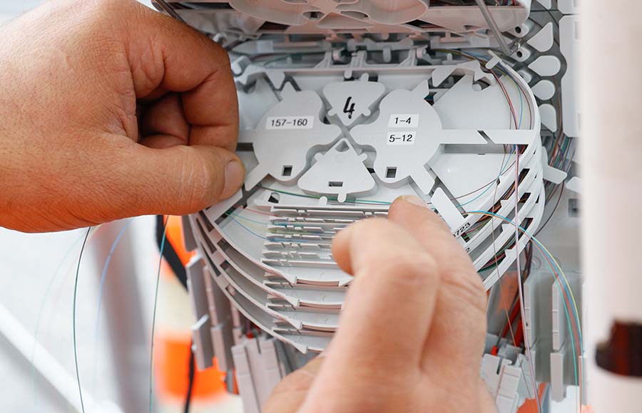 Tecnico al lavoro su un distributore di fibra – modello a quattro fibre per unità abitativa nella rete Chiasso4net